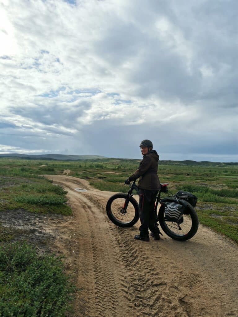 A woman on electric fatbike tour on a sand path in the wilderness in Enontekiö Lapland.