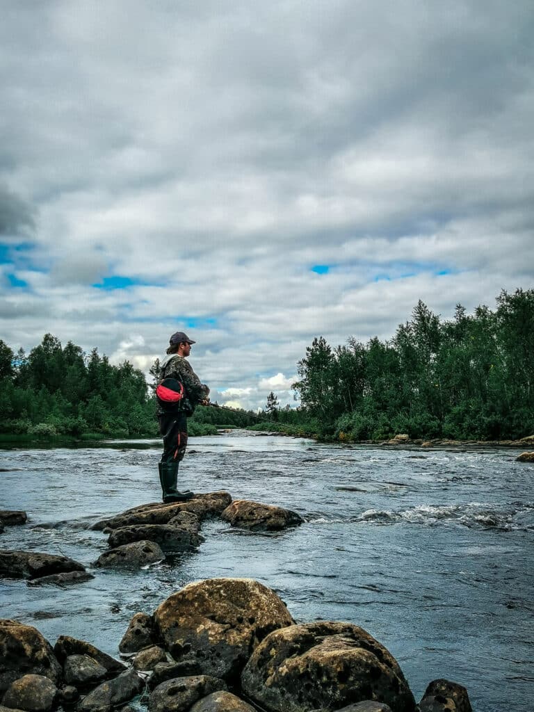 A man fishing in a river in Enontekiö Lapland.